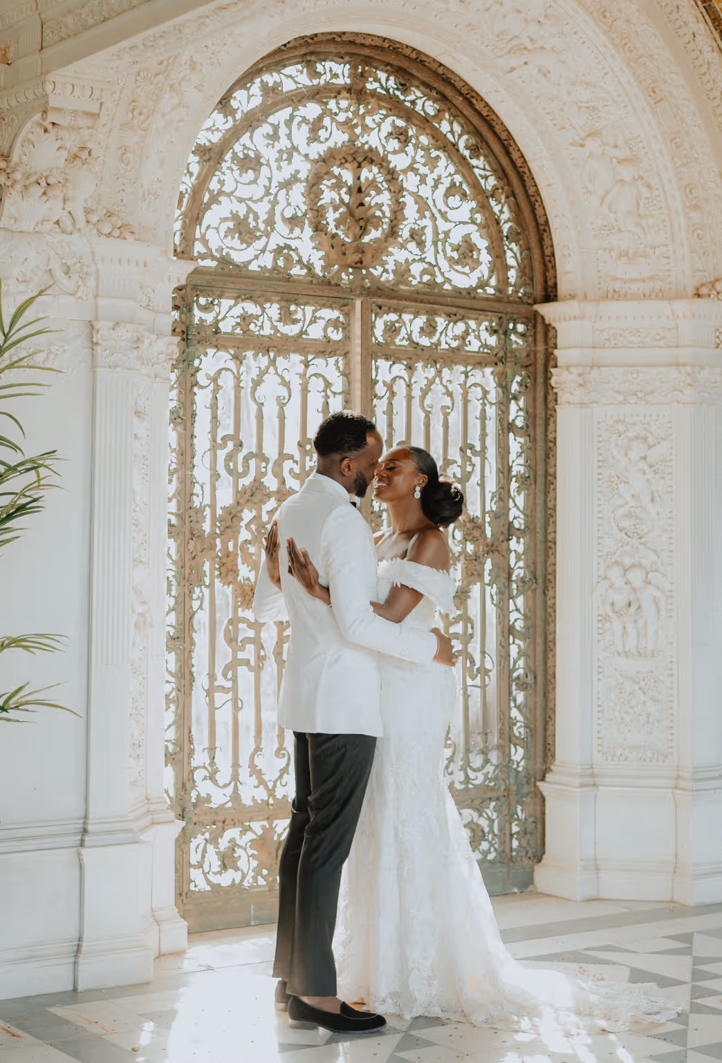 At North Mymms Park, a radiant African couple shares their first look as a married couple after a heartwarming civil ceremony. Behind them, a romantic Loggia adorned with elegant architectural details adds a timeless and enchanting charm to the joyous moment.