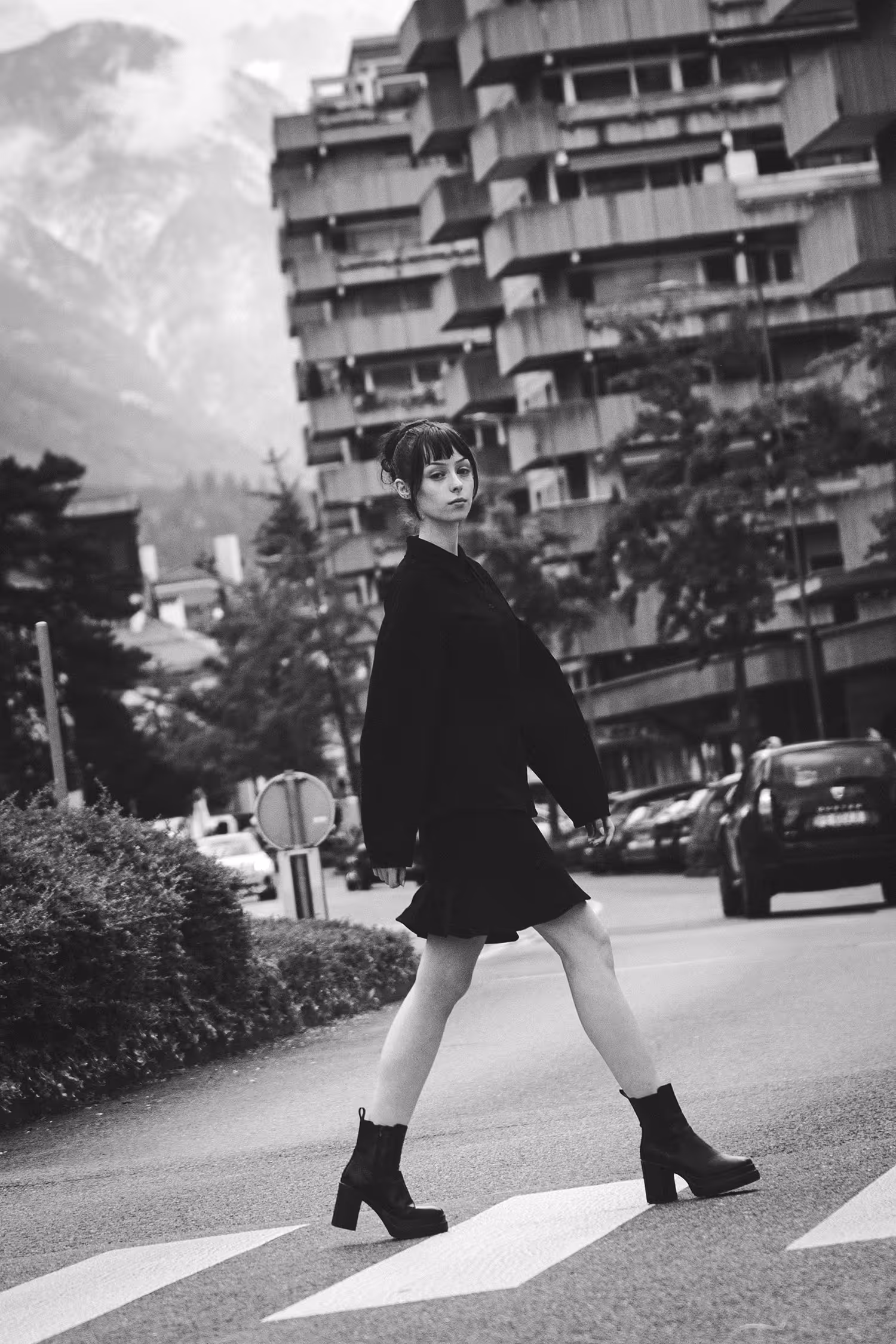 A woman dressed in black walking across the street in Innsbruck