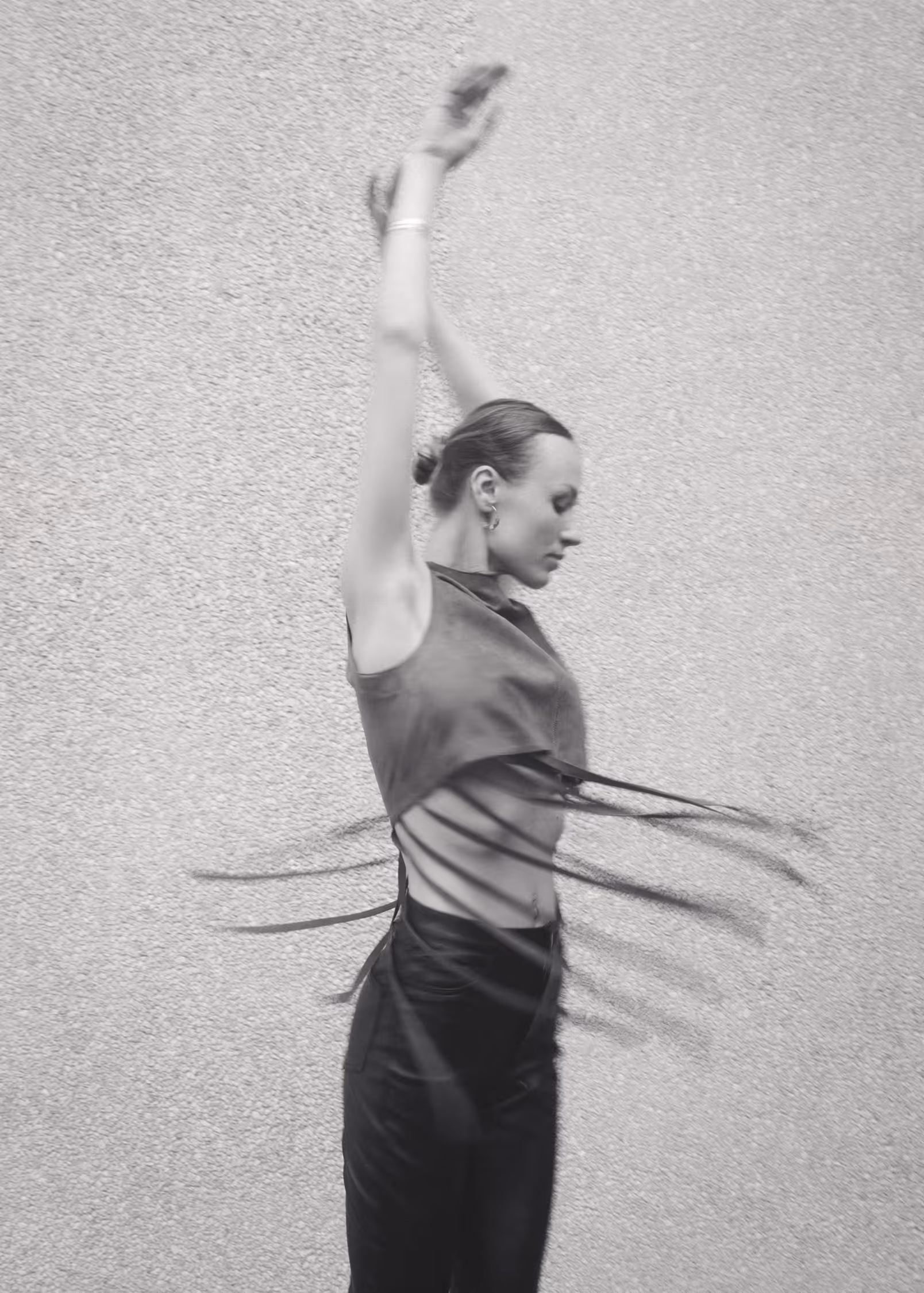 A woman in a fringed top in an artistic, dance-like pose