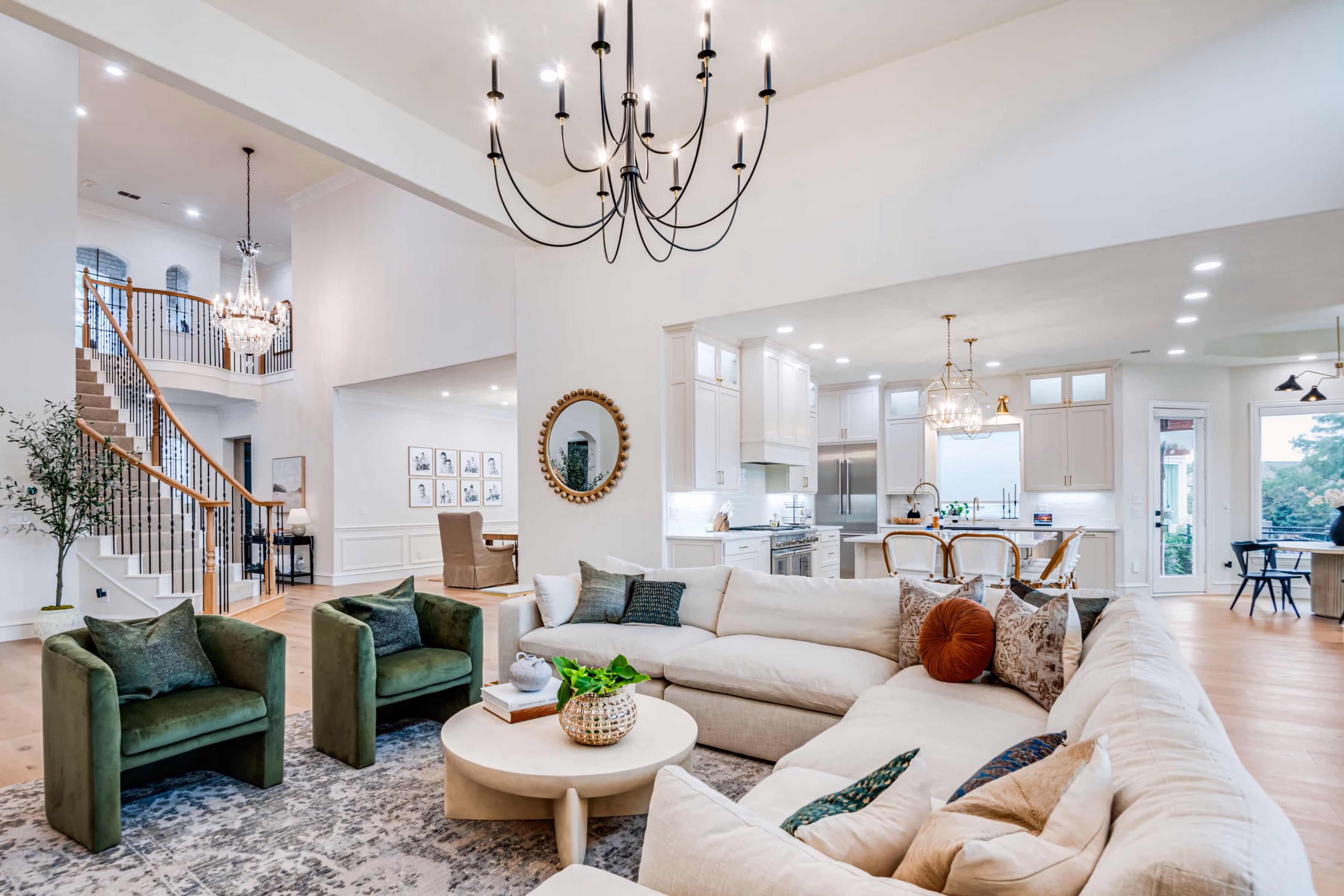 Bright open living room with beige sectional, blue rug, large windows, and stone fireplace with mirror.