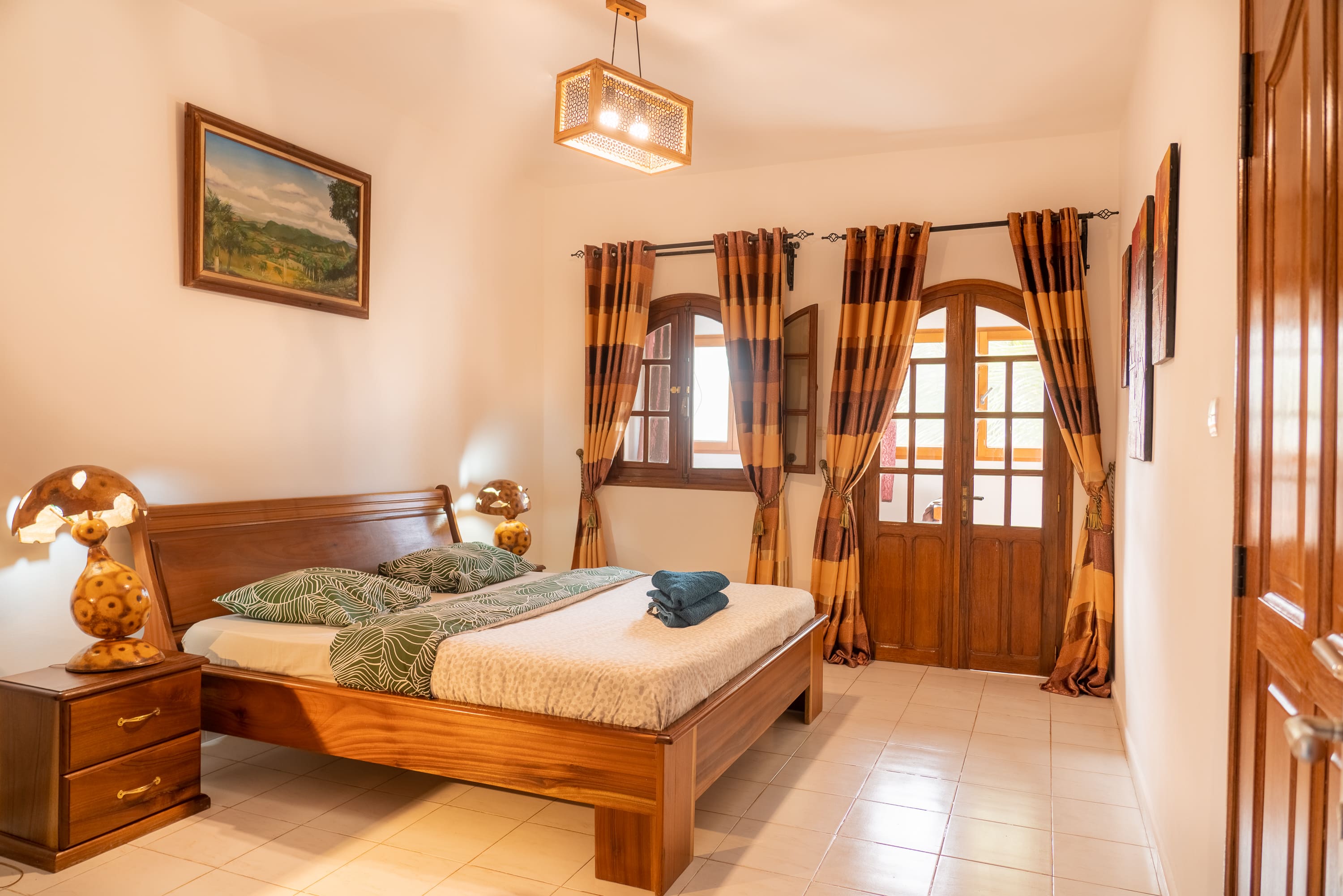 Chambre de la grande suite avec un grand lit et un balcon