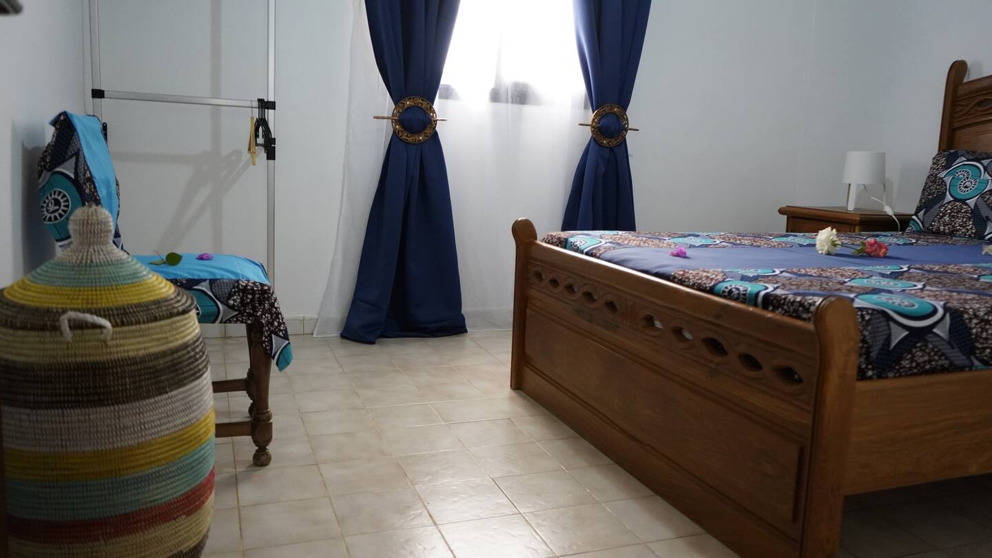 chambre avec un lit en bois et des draps bleus