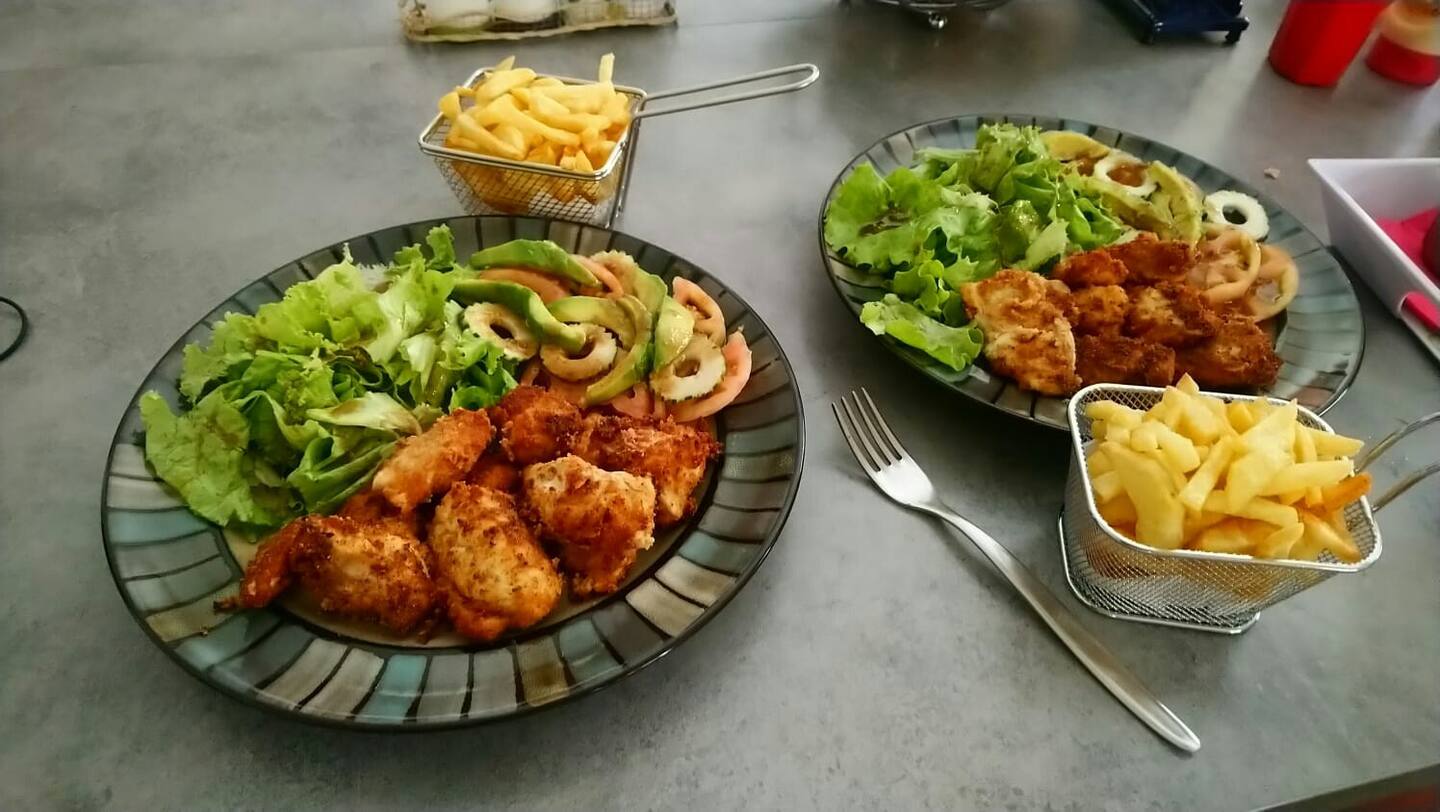 repas composé d'une salade verte et des crevettes
