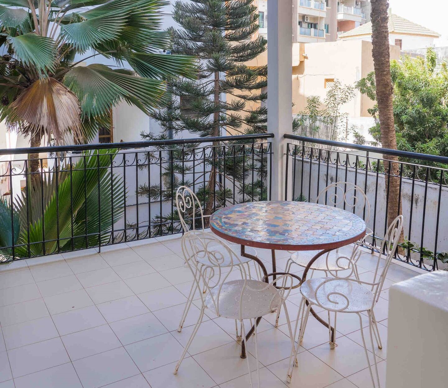 terrasse de las suite avec une table et des chaises en fer 