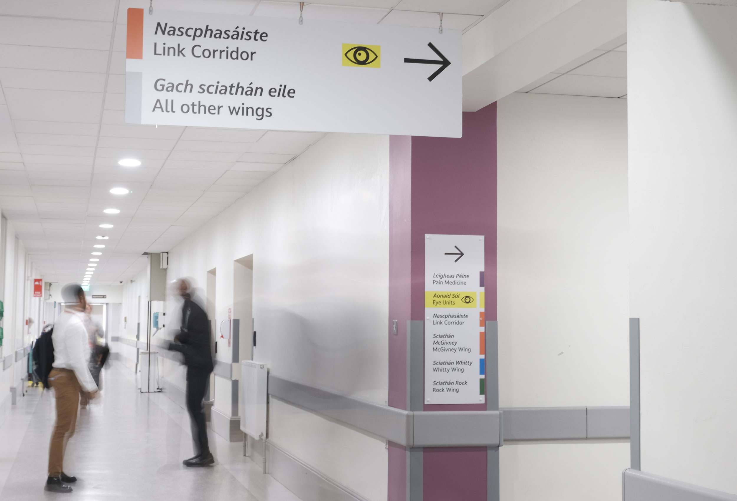 People walking past new signage for the Eye Department