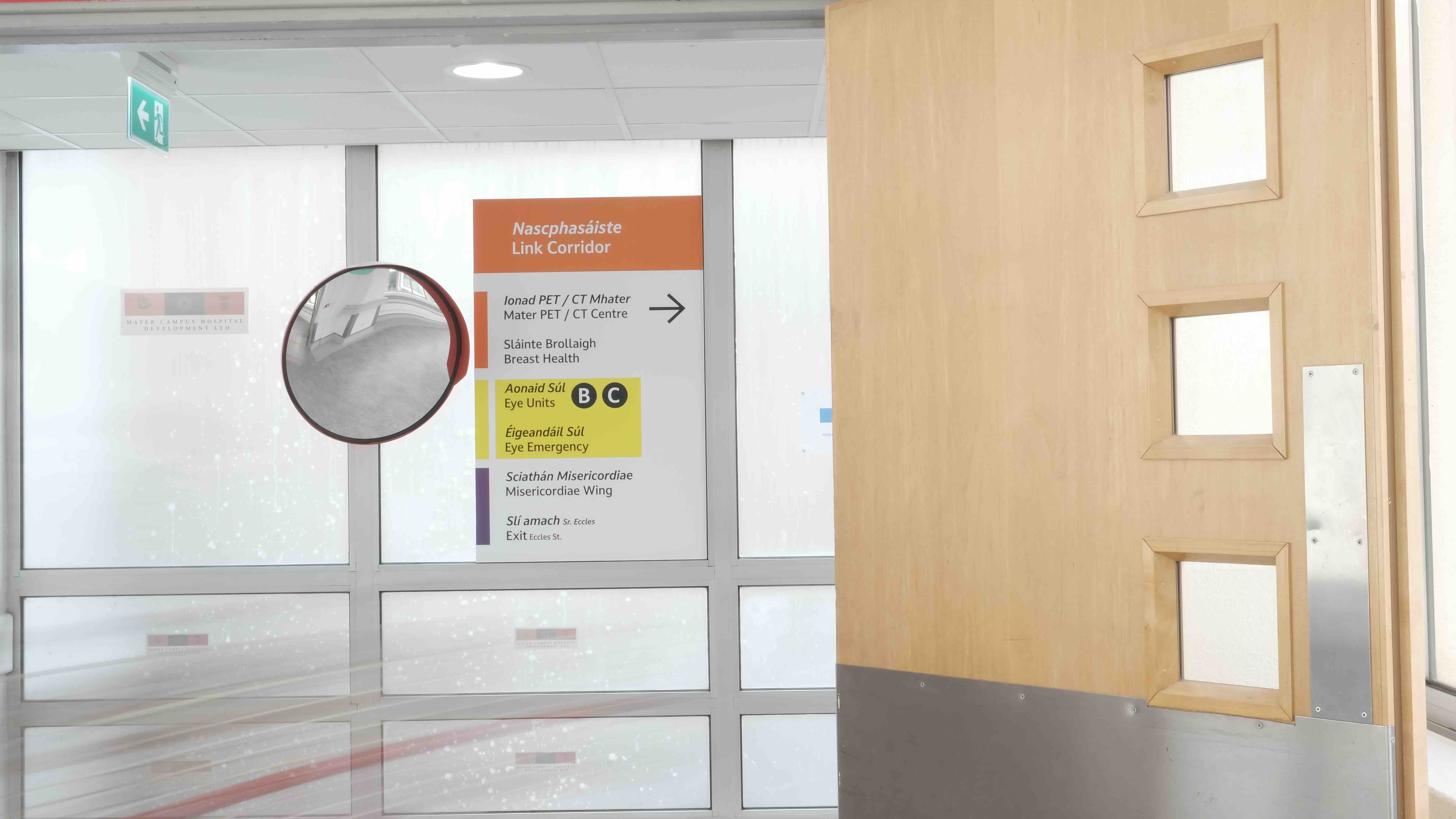 Signage on entry to the link corridor at the Mater Hospital in Dublin, directing users of the hospital to Eye Units B, C and Eye Emergency as well as Mater PET / CT centre, Breast Health , The Misericordiae Wing and Exit to Eccles Street. 