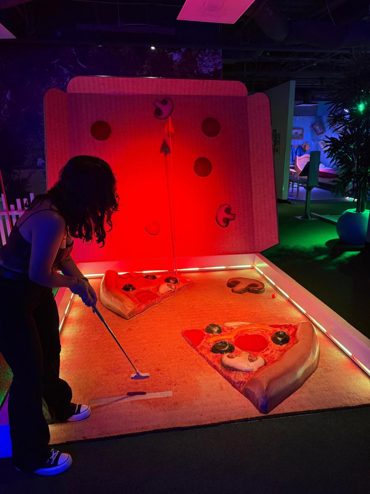 Uno studente di CWC su una buca del minigolf a tema pizza durante un'uscita sociale di Columbia West College a Los Angeles