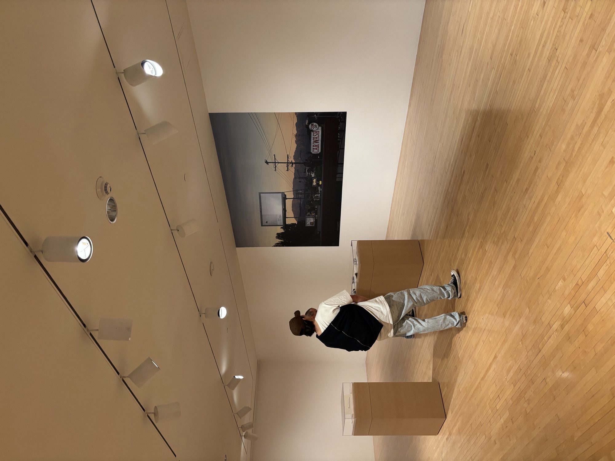 Studente di CWC che studia attentamente un'opera fotografica al MOCA, sviluppando l'attenzione ai dettagli che rafforza le competenze di scrittura professionale