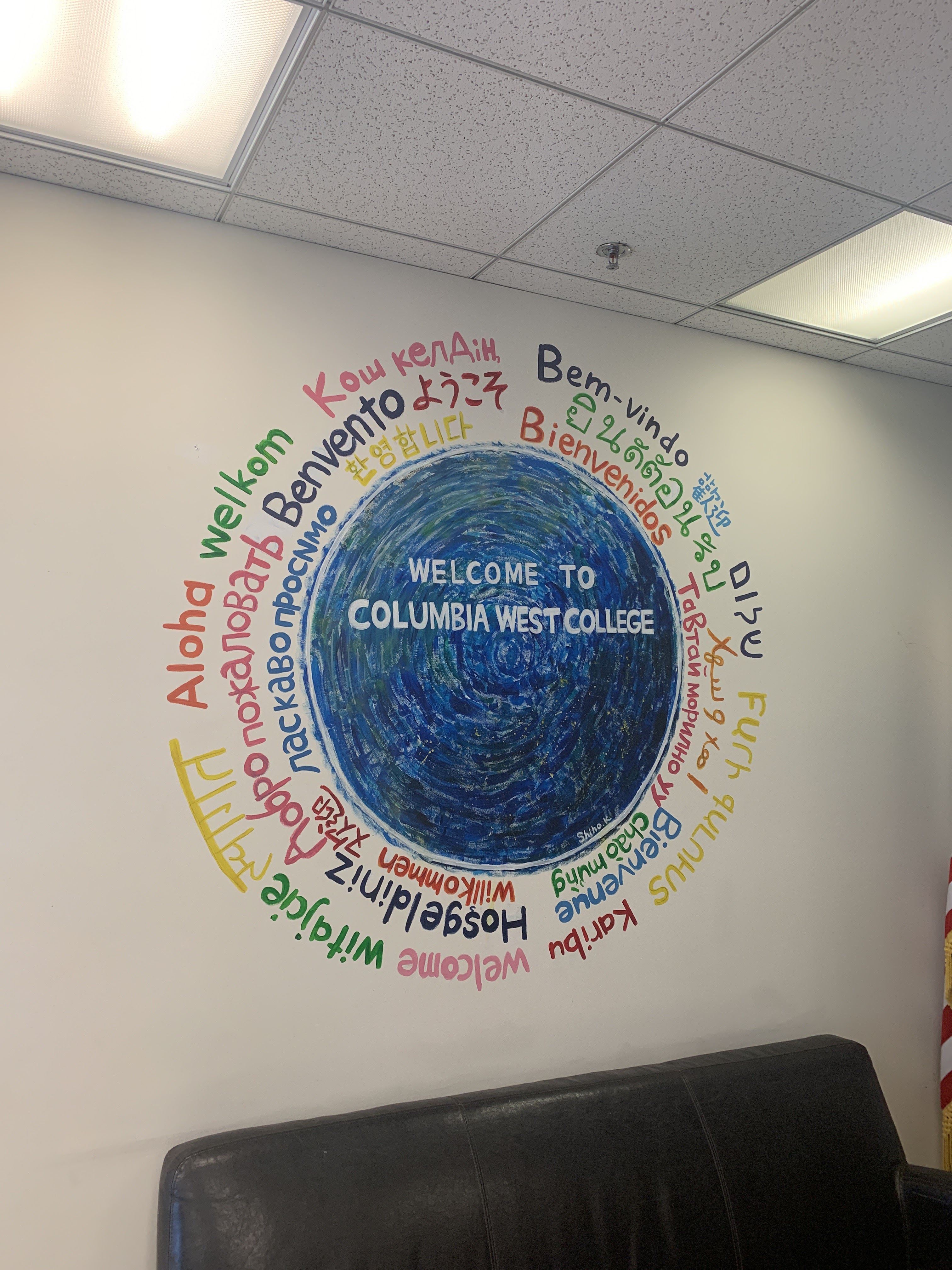 Fresque murale multilingue d'accueil sur le campus de Columbia West College, reflétant les diverses origines linguistiques des étudiants ESL qui apprennent la prononciation de l'alphabet anglais