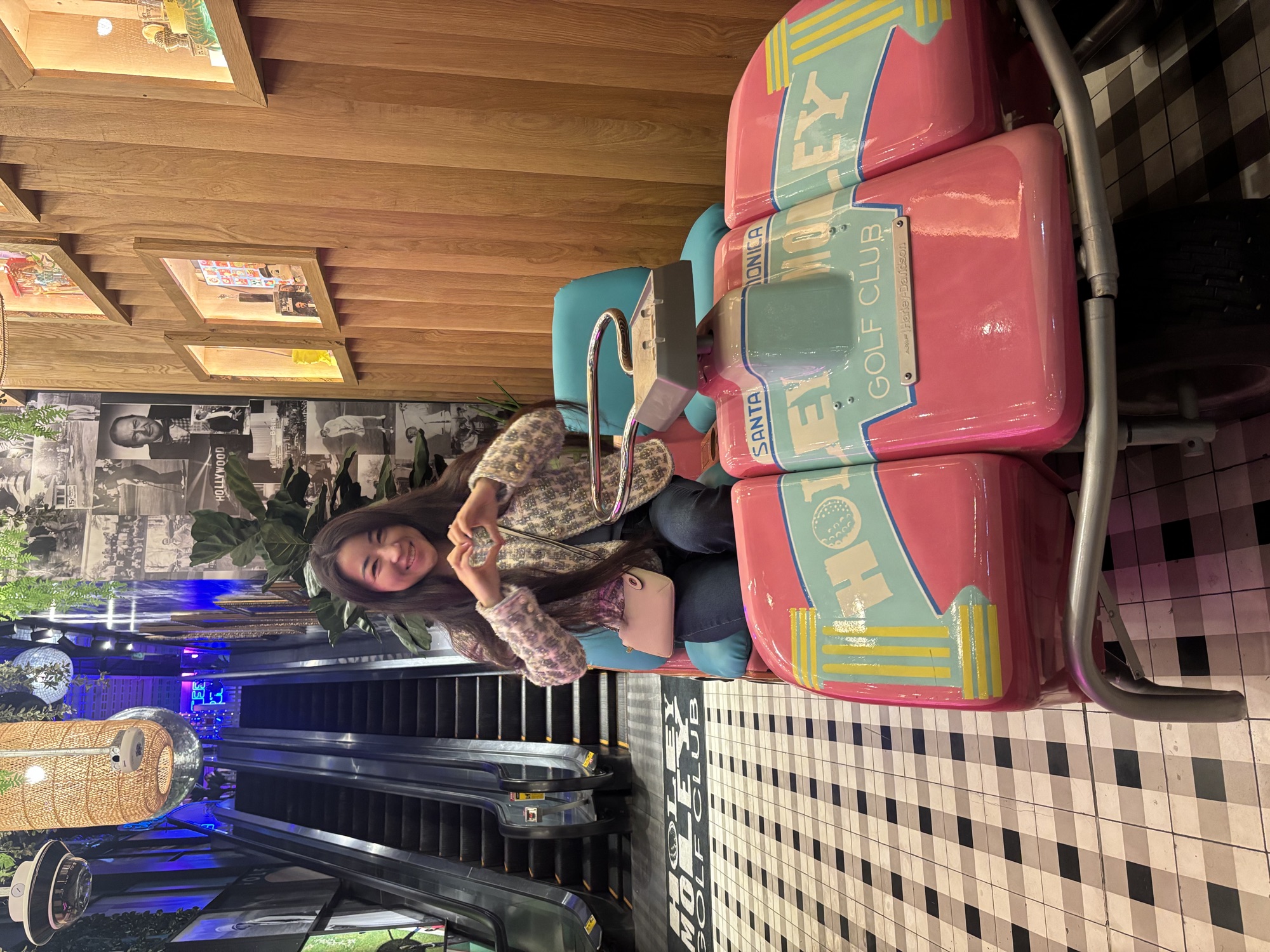 Columbia West College student posing on a pink golf cart at mini golf, enjoying social English practice outside the classroom