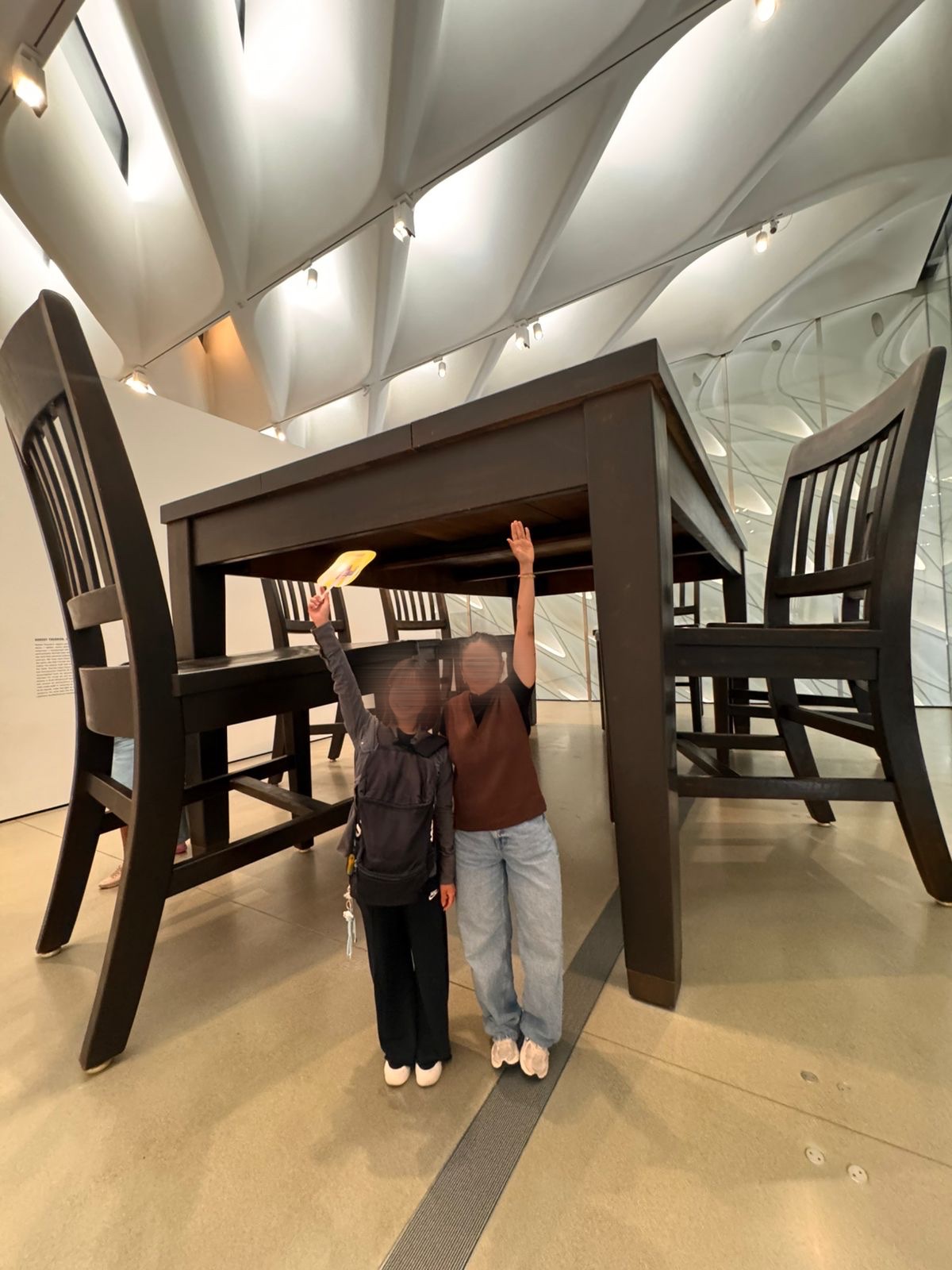 Two CWC students with a giant sculpture on a museum field trip, practicing English conversation in a natural setting