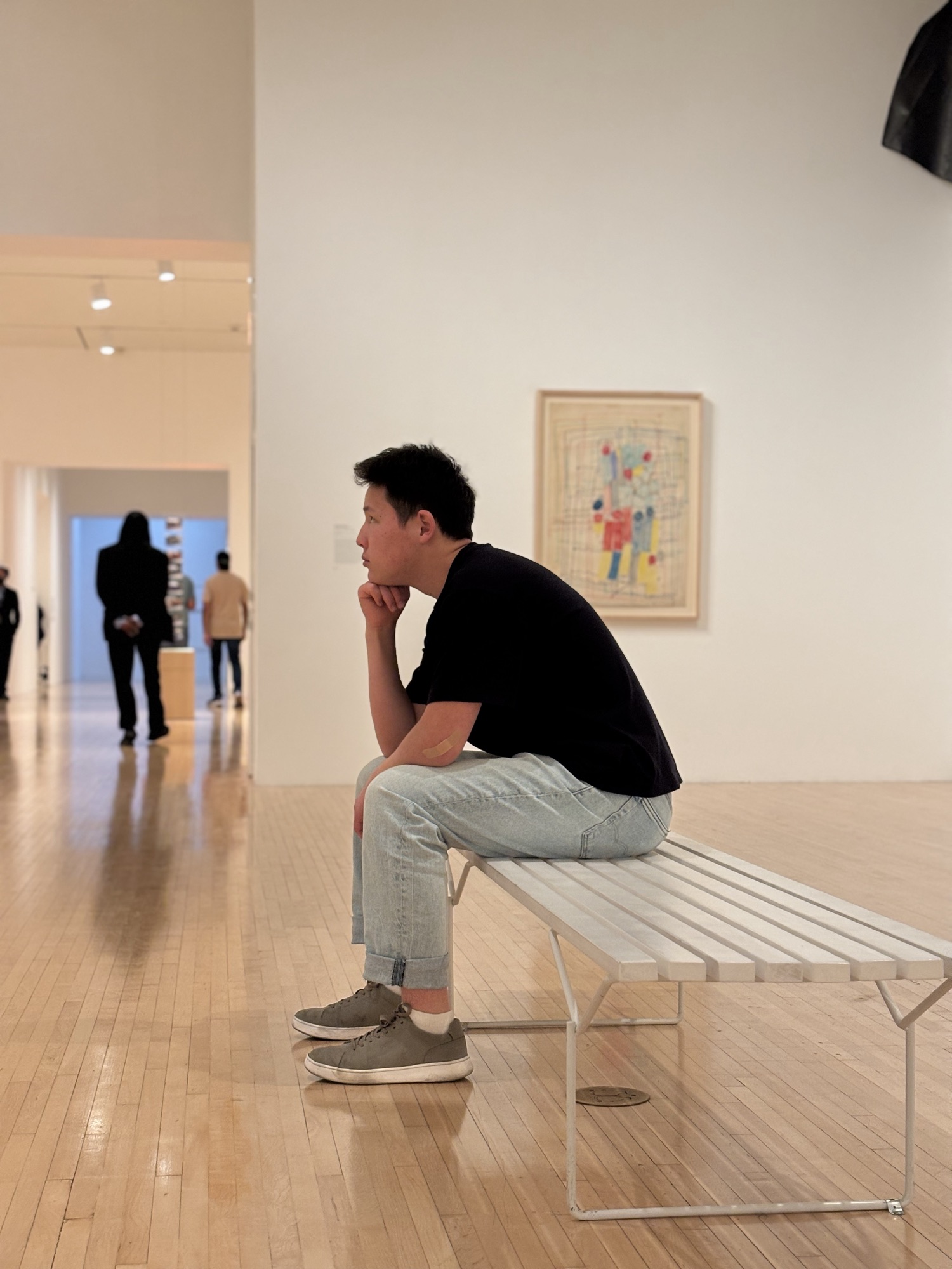 CWC student sitting on a gallery bench at MOCA, reflecting thoughtfully — a mood that mirrors the focus needed to build writing skills
