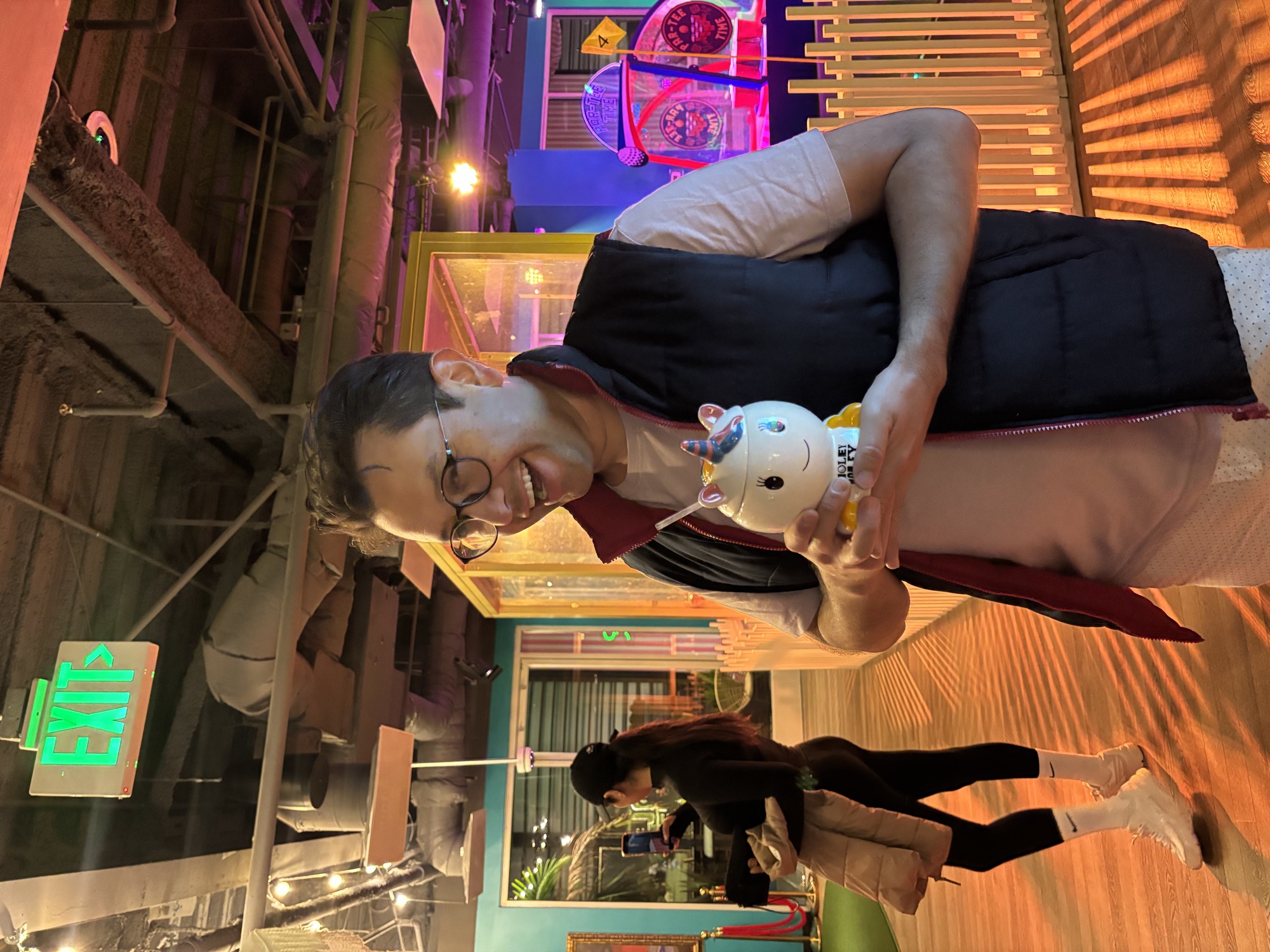 CWC student smiling with a unicorn drink at mini golf — casual outings help Columbia West College students practice everyday English conversation in real situations
