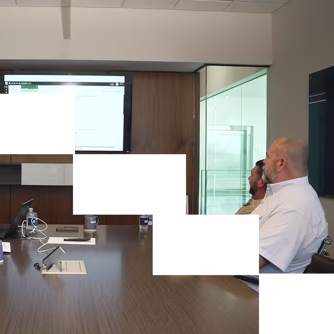 Team of construction professionals walk a jobsite in high visability gear and hard hats.