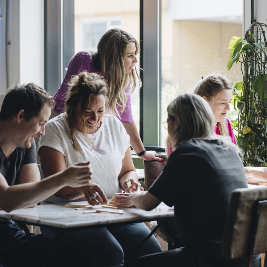 Trainer en coach Amanda Ronhaar van Toer de Werkvloer met een team van professionals tijdens een oefening met blokjes.