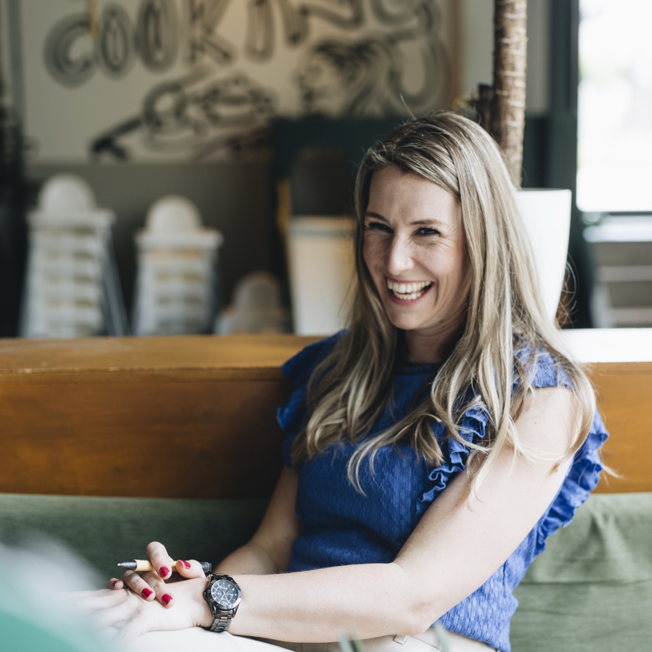 Trainer en coach Amanda Ronhaar van Toer de Werkvloer lachend tijdens een coachingsgesprek.