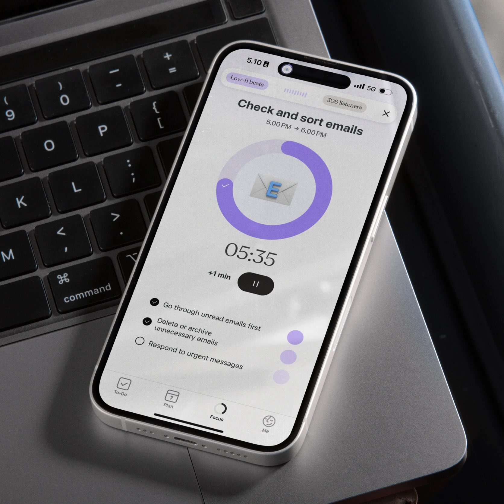 A smartphone on a laptop showing a Tiimo focus timer for checking emails, with a visible checklist and countdown clock.