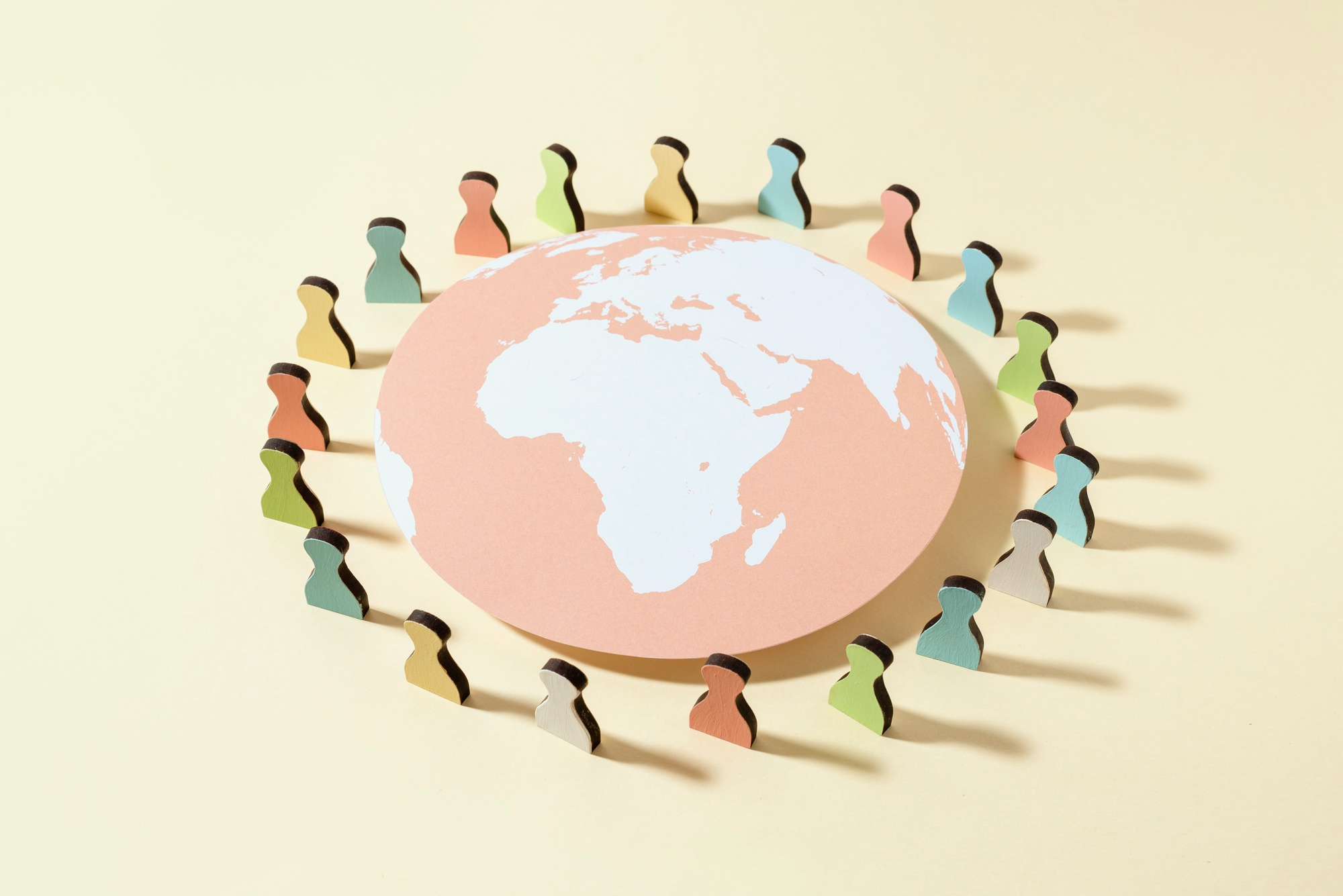 Papiererdkugel mit Spielfiguren drumherum