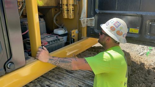 A worker checking an equipment's battery