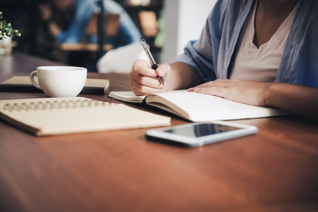 A women working at desk with papers and notes on table