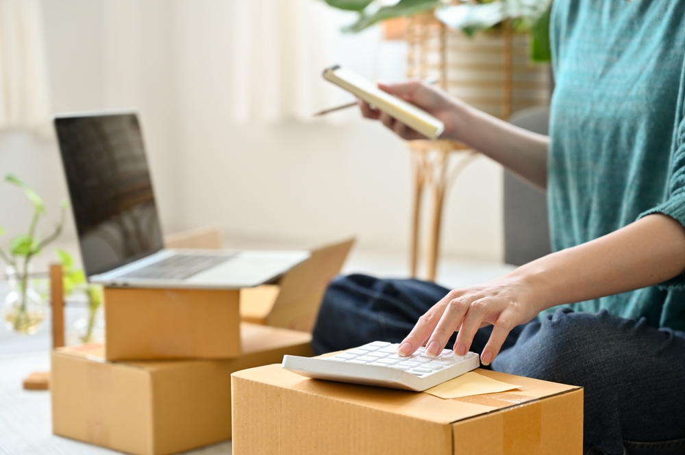 woman with a calculator, laptop and packages