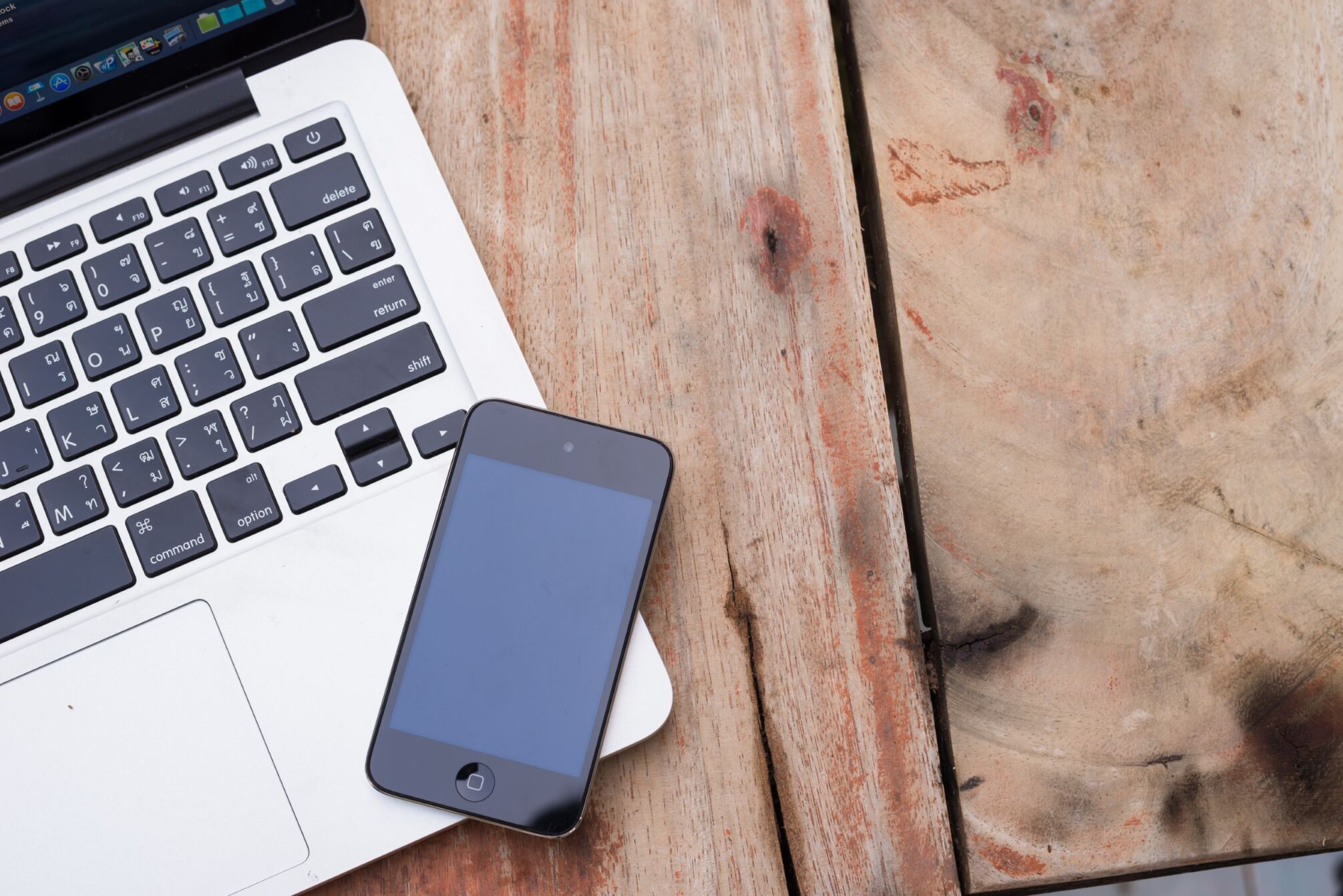 a mobile phone and a laptop on a desk