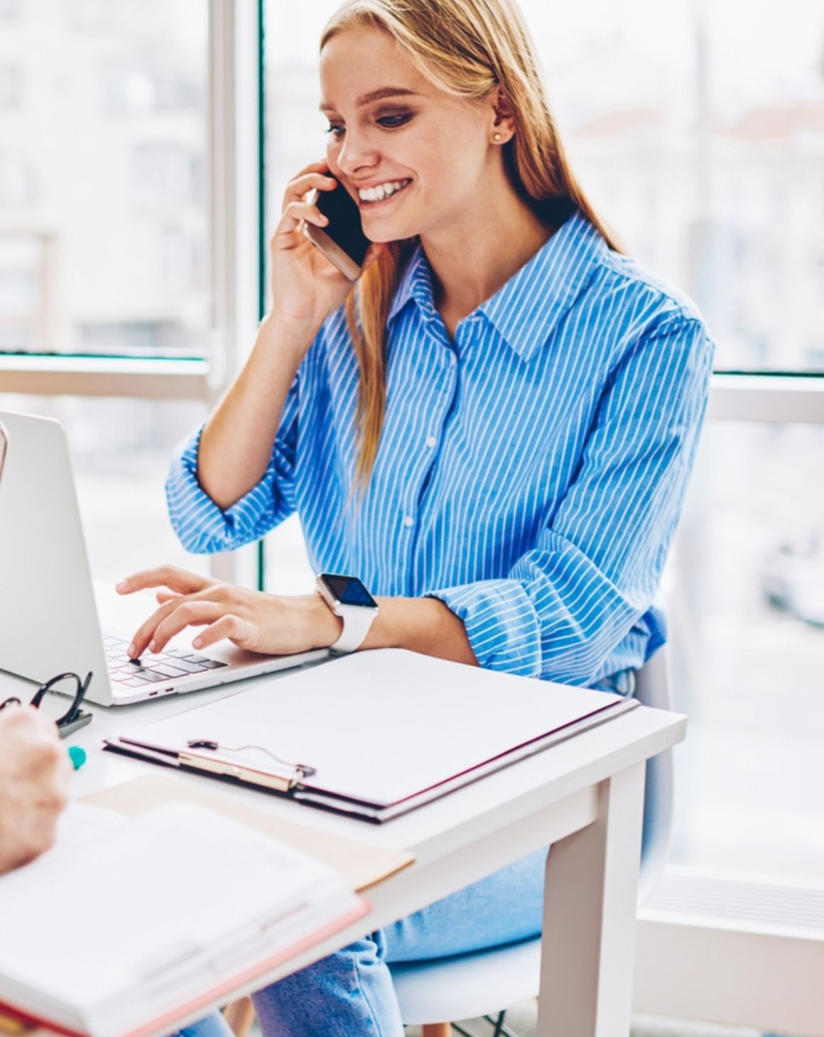 woman sitting at a desk on the phone