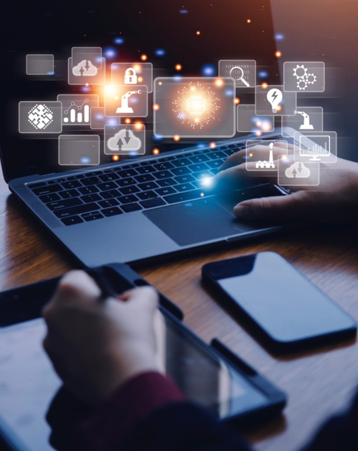 hands typing on a desk with a computer, smart phone and tablet