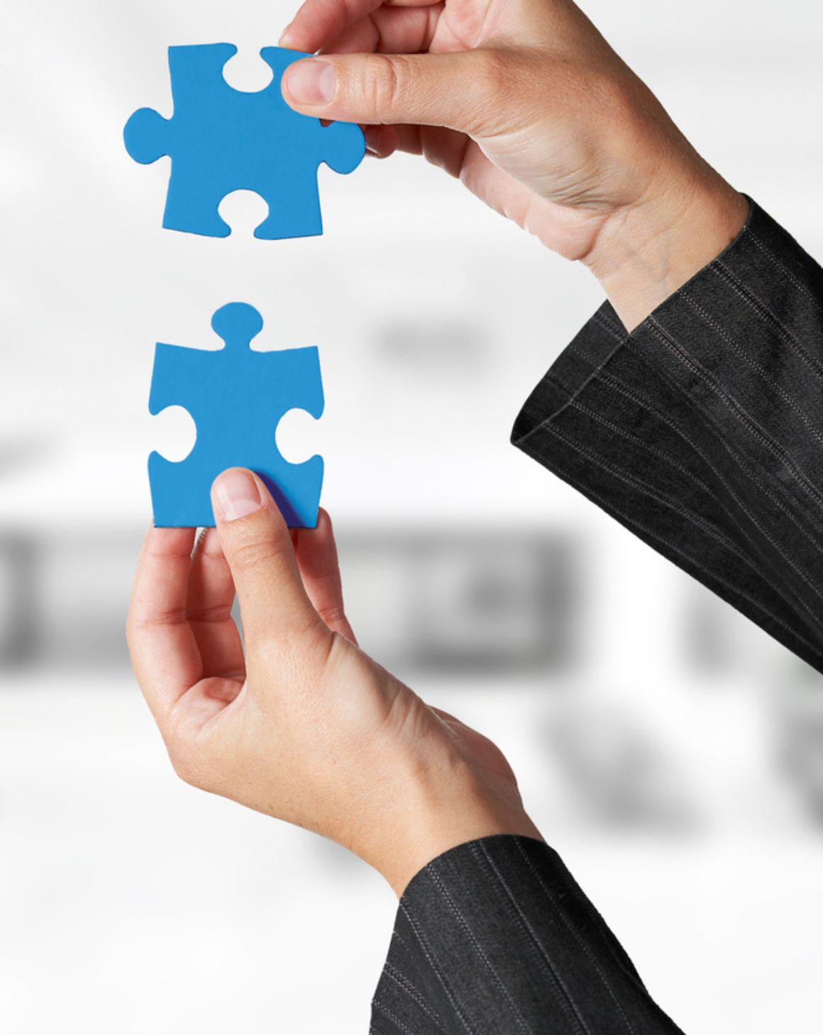two hands holding blue puzzle pieces