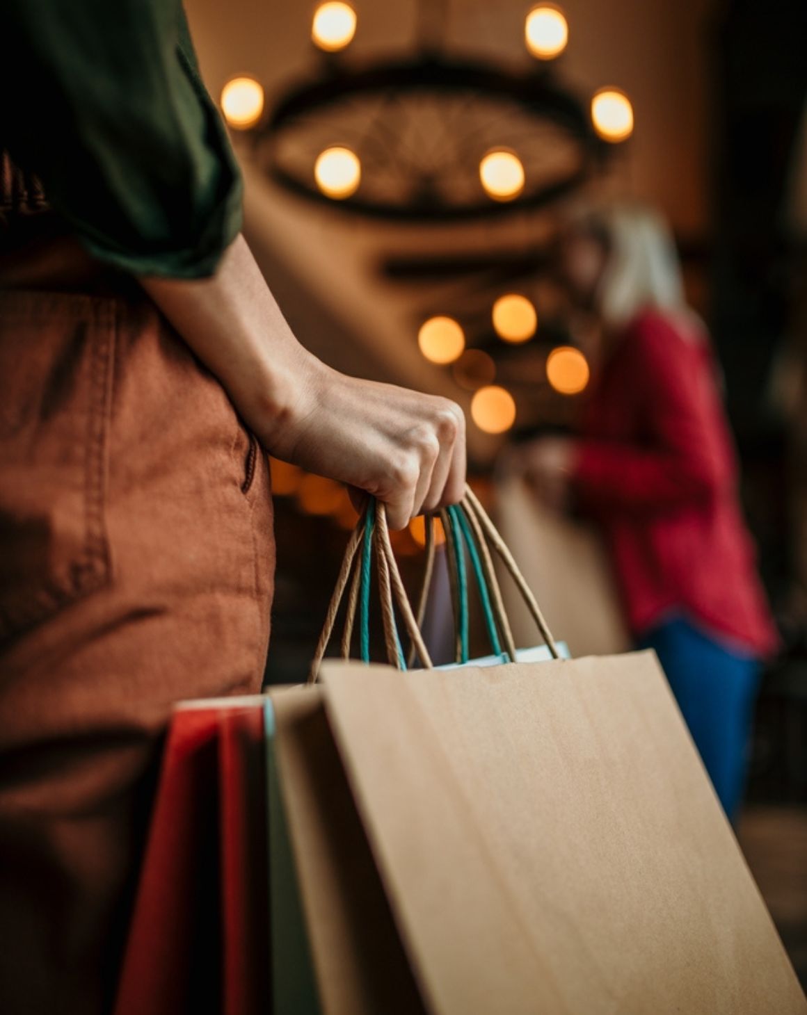 woman holding multiple shopping bags while standing inside a store