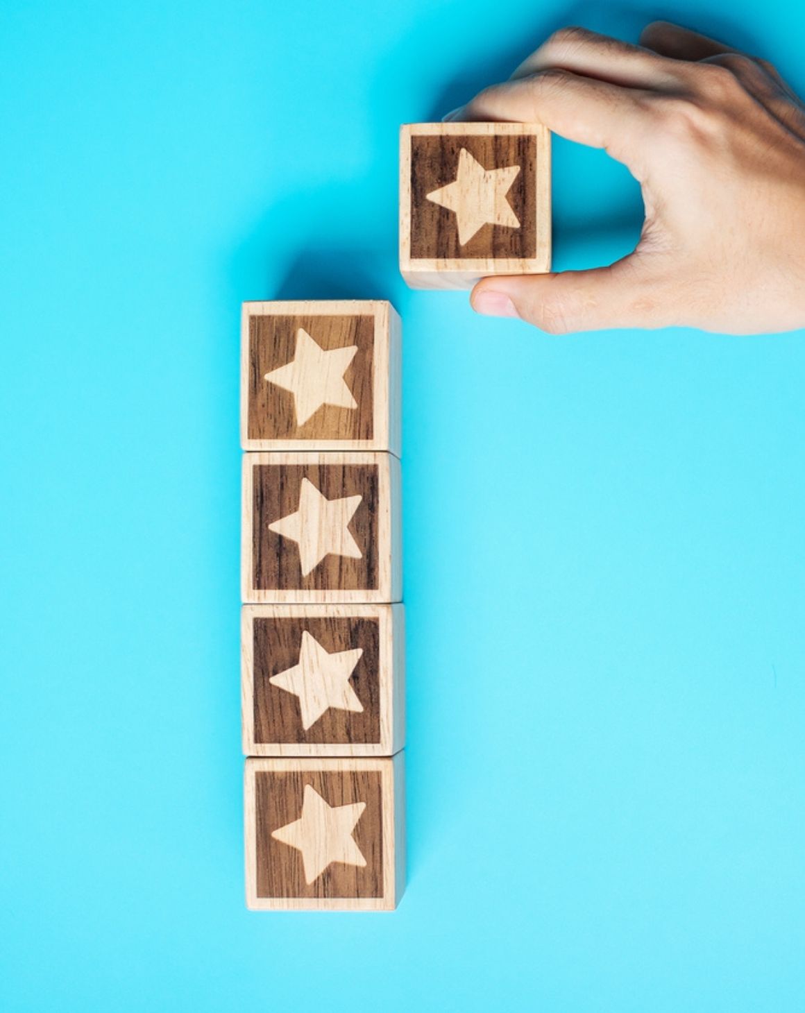 a person holds wooden blocks decorated with stars