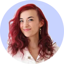 Smiling woman with long red hair and gold earrings against a light blue circular background.