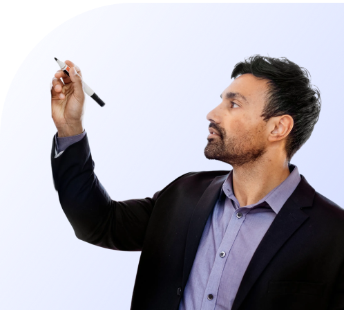 Man in a dark blazer and purple shirt holding a black and white marker as if writing on a board.