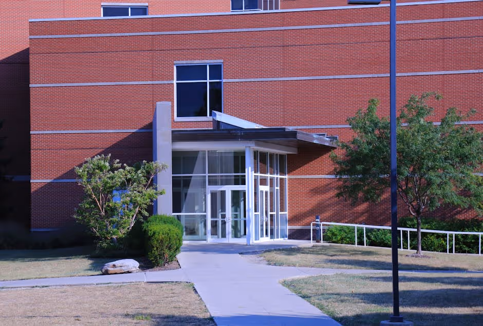Red brick building entrance with glass doors and accessible ramp