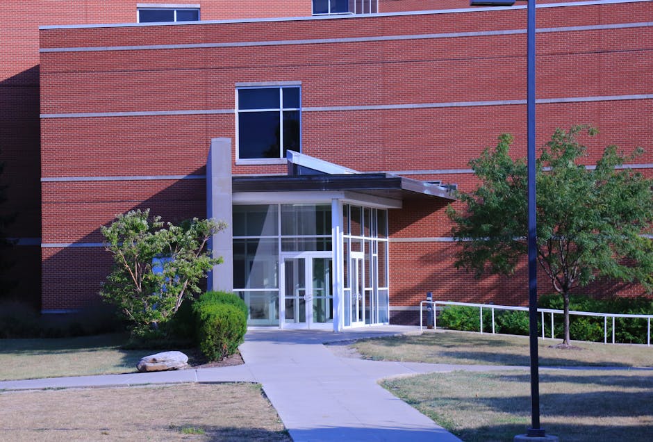 Red brick building entrance with glass doors and accessible ramp