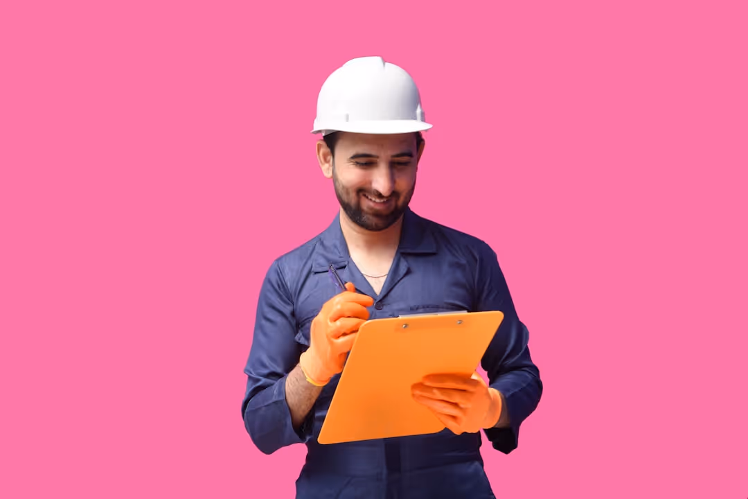 Construction worker in white helmet takes notes on orange clipboard