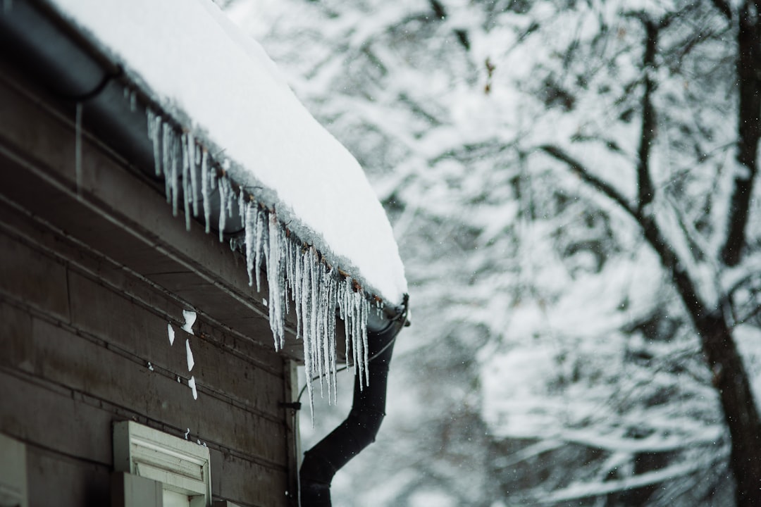 A snow-covered roof with icicles hanging from the gutters in a residential Massachusetts neighborhood - homeowners insurance worcester ma A snow-covered roof with icicles hanging from the gutters in a residential Massachusetts neighborhood - homeowners insurance worcester ma