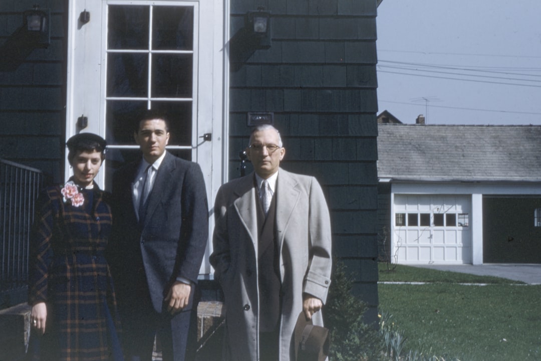 Happy family standing in front of their home in Needham - house insurance massachusetts Happy family standing in front of their home in Needham - house insurance massachusetts