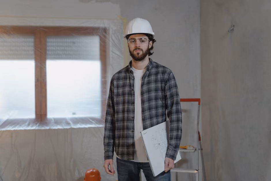 A fire protection contractor carefully reviewing building blueprints on a job site in Newton, MA. - fire protection contractor insurance