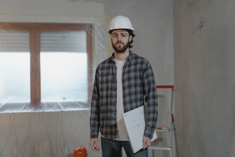 A fire protection contractor carefully reviewing building blueprints on a job site in Newton, MA. - fire protection contractor insurance