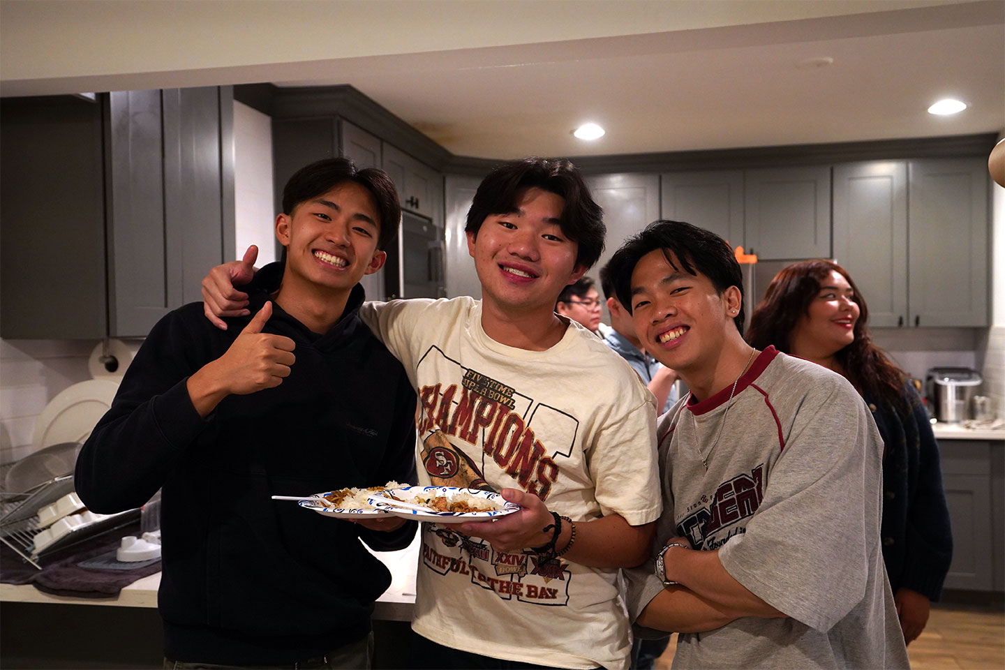 Three guys smiling holding up dinner plate