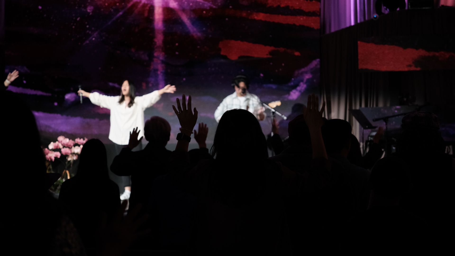 Worship team praise and worship on stage with purple LED background