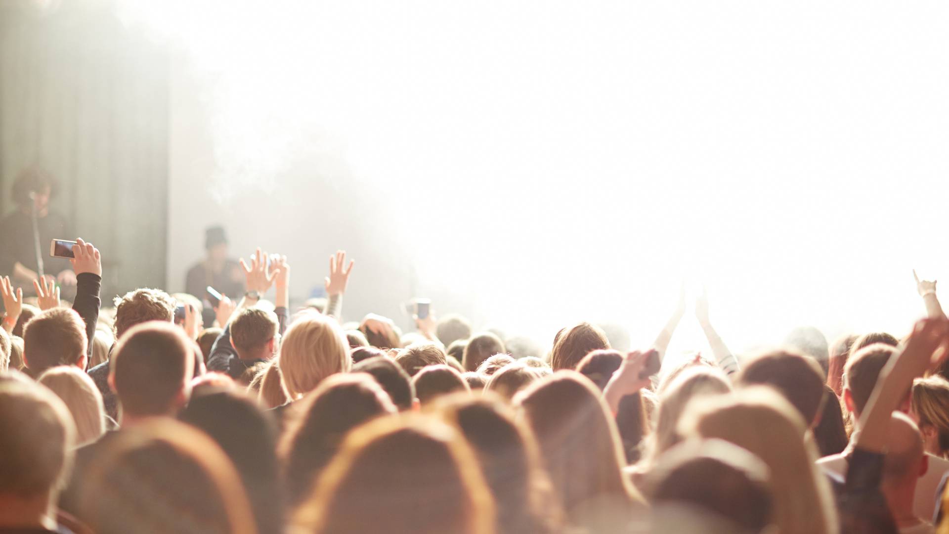 People worshipping in a crowd in a bright light
