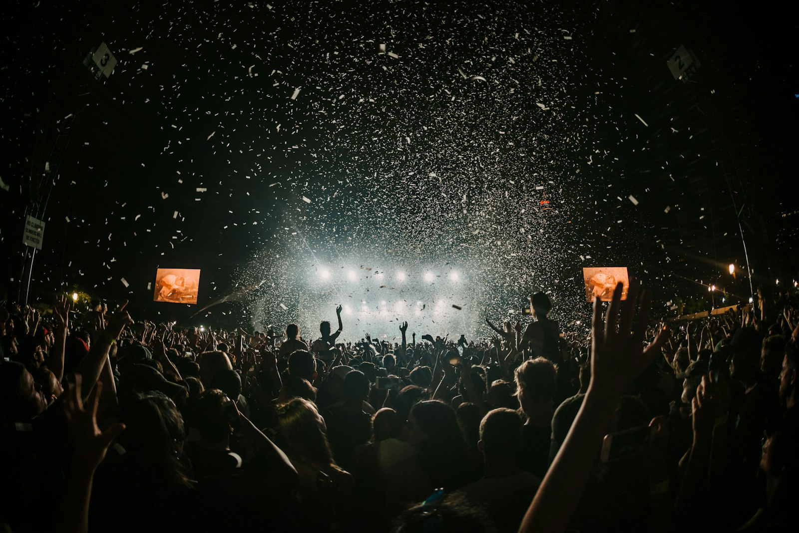 Festival crowd in front of a stage with confetti falling