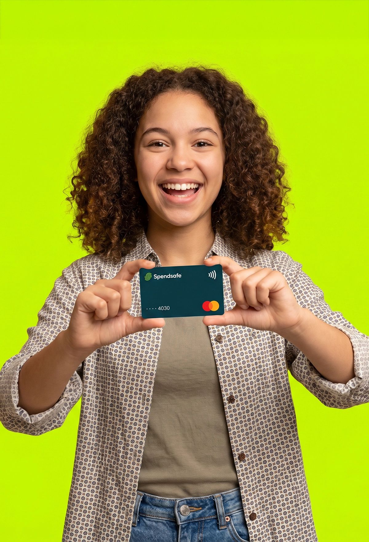 Image of an excited girl with a neon green background behind, excitedly holding up a spendsafe debit card