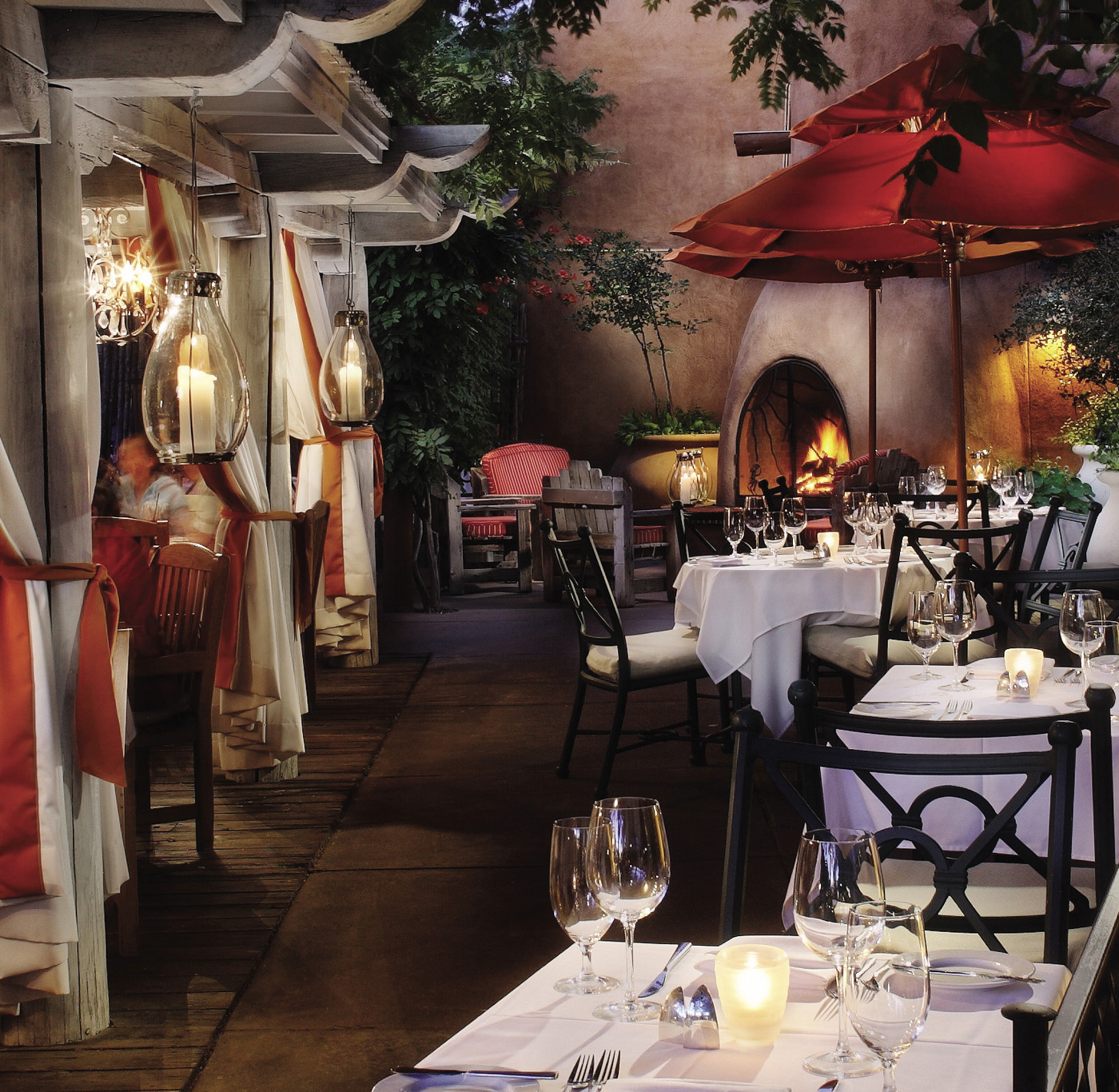Luminaria patio with tables set for dinner and fireplace in background