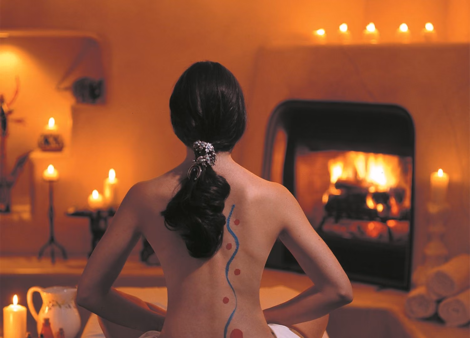 Woman with back facing camera facing fireplace