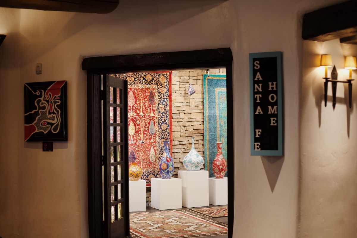 Entrance to Santa Fe Home shop with various vases and rugs hanging on wall