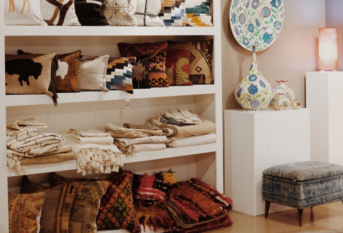 Shelf of pillows and rugs in Santa Fe Rugs shop