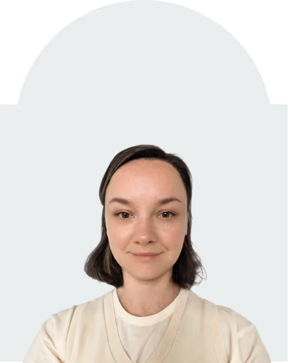 Portrait of a woman with short brown hair wearing a cream-colored sweater, against a light gray background with an arch shape at the top.